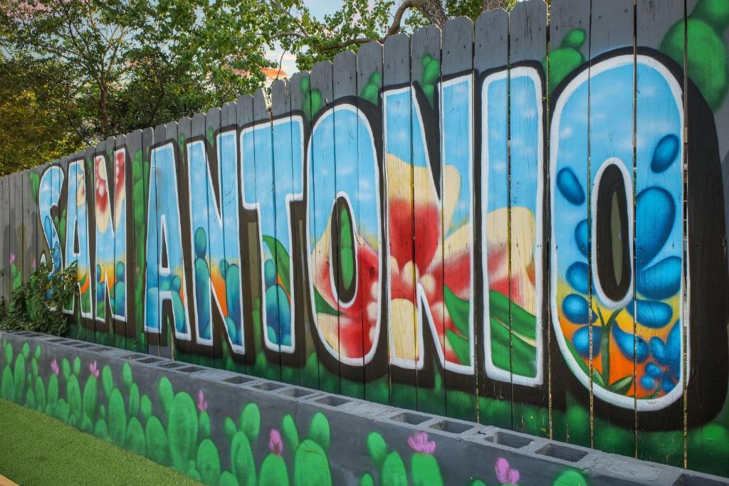 a fence with graffiti on the side of it at Great home, great location at a great price! in San Antonio