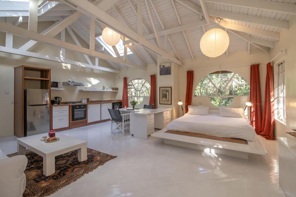 a large bedroom with a bed and a kitchen at Windy Ridge Gem Studio by YourHost Karen Nairobi in Nairobi