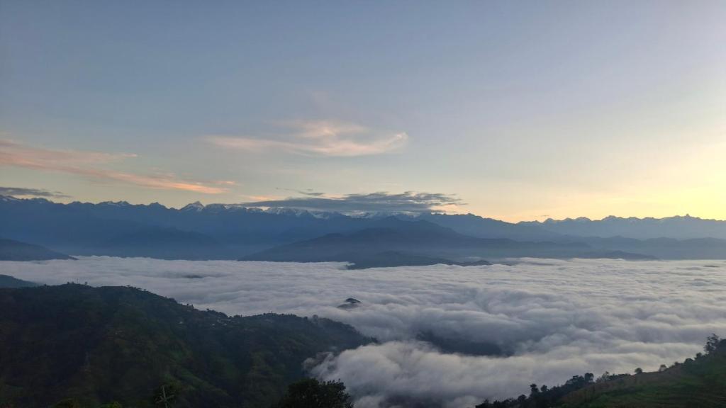 a view of a valley of clouds in the mountains at Khasre Gurung Gaun Homestay in Nagarkot