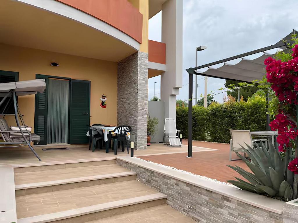 a patio with a table and chairs and an umbrella at Villa Costa del Sole - Capitolo in Monopoli