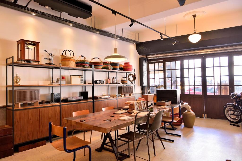 una sala da pranzo con tavolo e sedie in legno di OrigInn Space a Taipei
