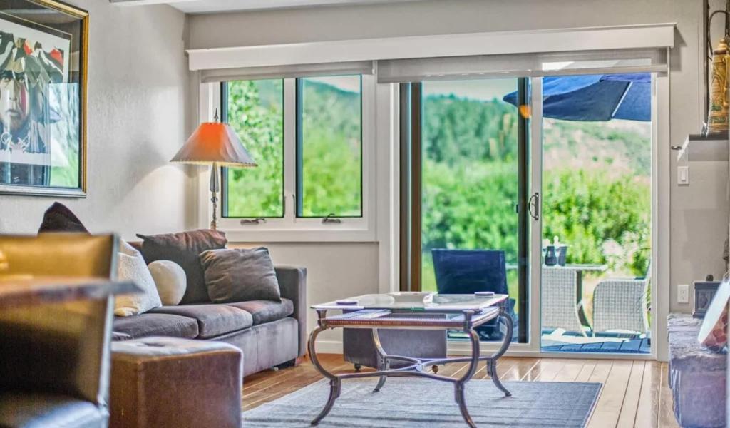 un salon avec un canapé et une table dans l'établissement Retreat with Creekside Patio Snowmass Village, à Snowmass Village