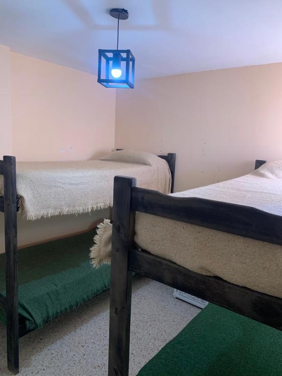 a bedroom with two beds and a blue light at Hostel Chillhouse in La Lucila del Mar