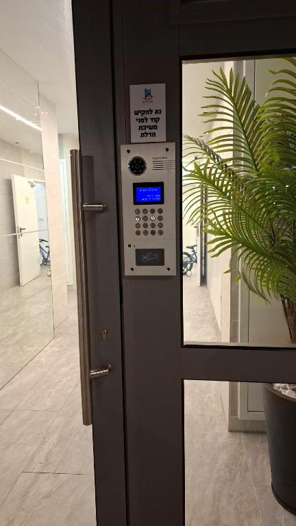 a machine in an office with a plant next to it at K Home כרמי גת in Qiryat Gat