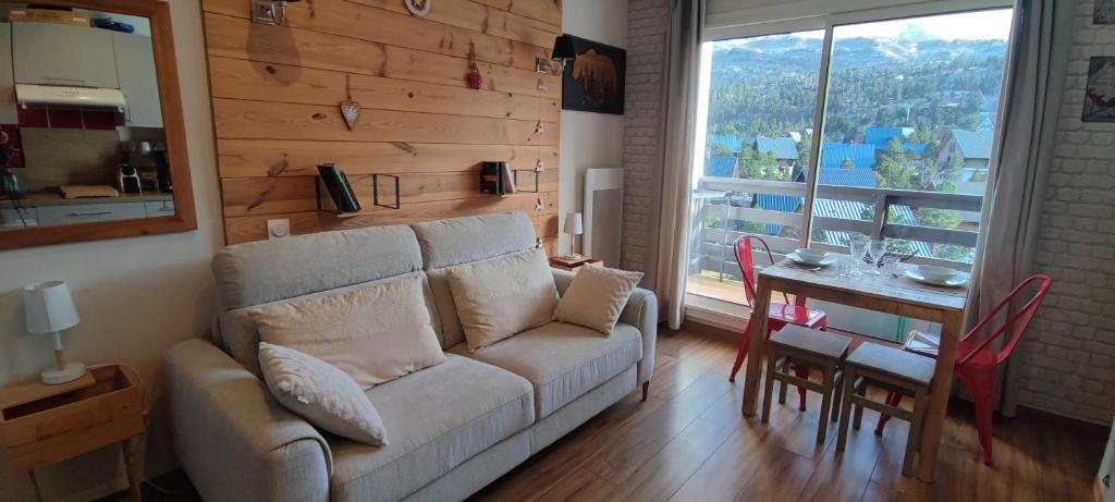a living room with a couch and a table at studio Loubat pyrénée, ménage inclus in Arette