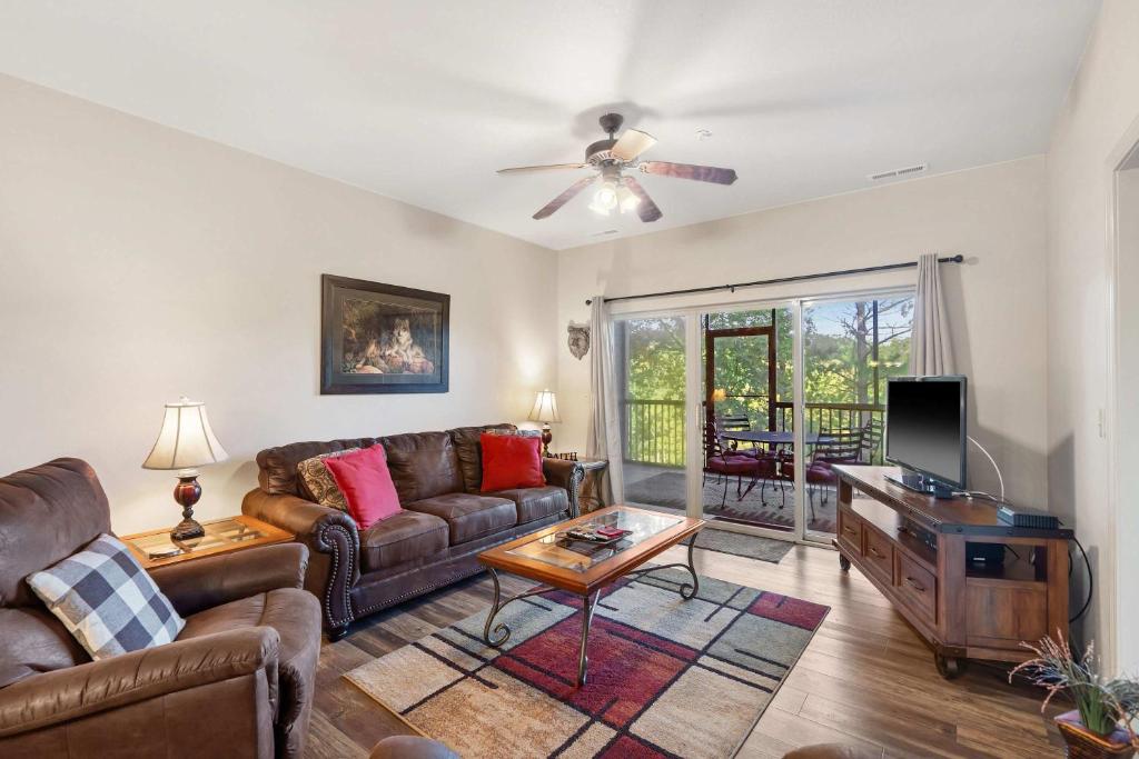 a living room with a couch and a tv at Fairway To Heaven - For 8ppl in Branson West