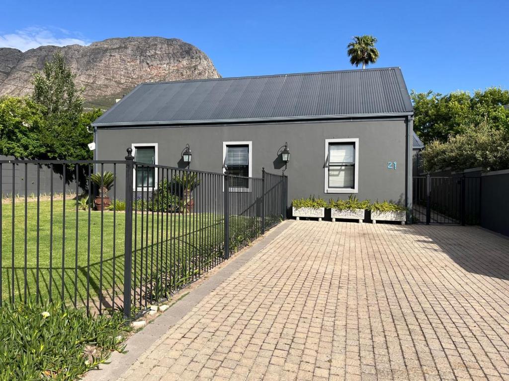a gray house with a fence in front of it at Franschhoek Guest Suite in Franschhoek
