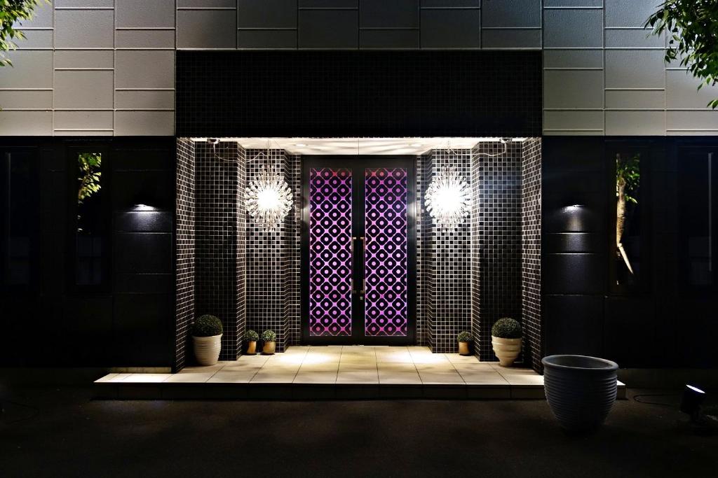 una puerta delantera de un edificio con macetas en HOTEL EVERMORE -Adult Only-, en Hirosaki