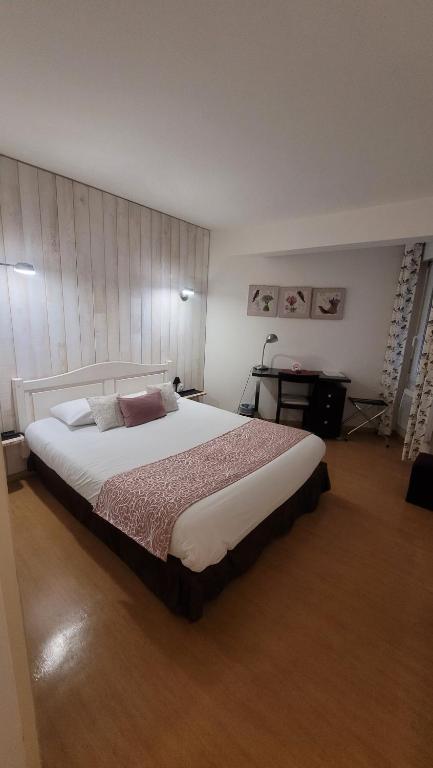 a bedroom with a large bed in a room at Au P'tit Creux des Landes in Ychoux