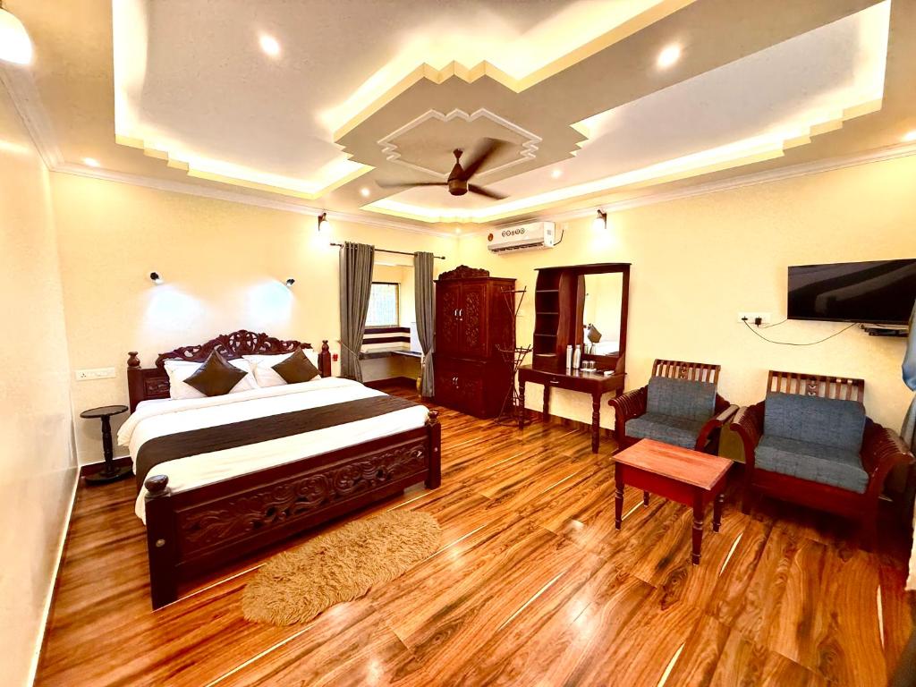 a bedroom with a bed and a couch and a tv at Almond Villa in Kappil