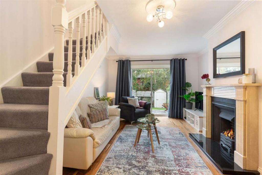 a living room with a staircase and a fireplace at GuestReady - Coastal Charm near Sandymount Beach in Dublin