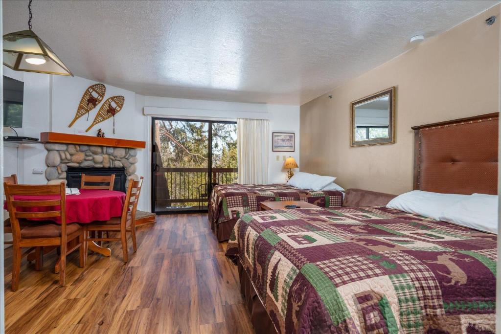 - une chambre avec 2 lits, une table et une cheminée dans l'établissement (B109) Studio Condominiums, à Yosemite West