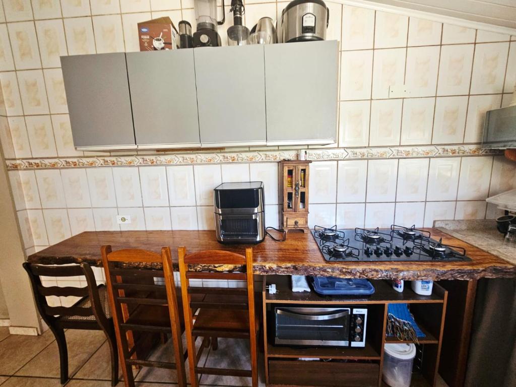 una cocina con encimera, fogones y microondas en Casa Central Ubatuba, en Ubatuba