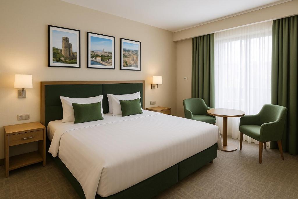 a hotel room with a large bed and two chairs at Rest Deluxe Hotel in Baku