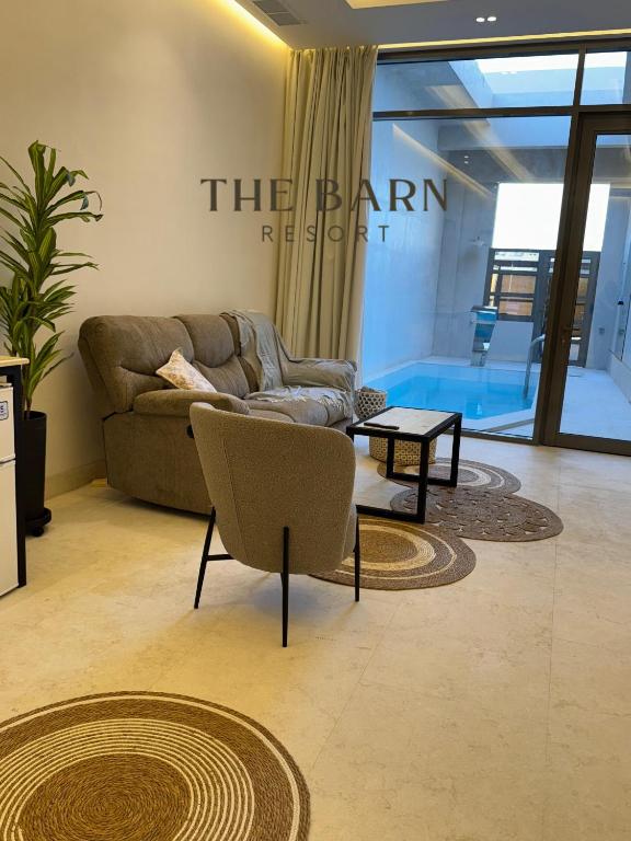 ein Wohnzimmer mit Sofa und Tisch in der Unterkunft The Barn Resort Sea View منتجع ذا بارن in An Nāmī