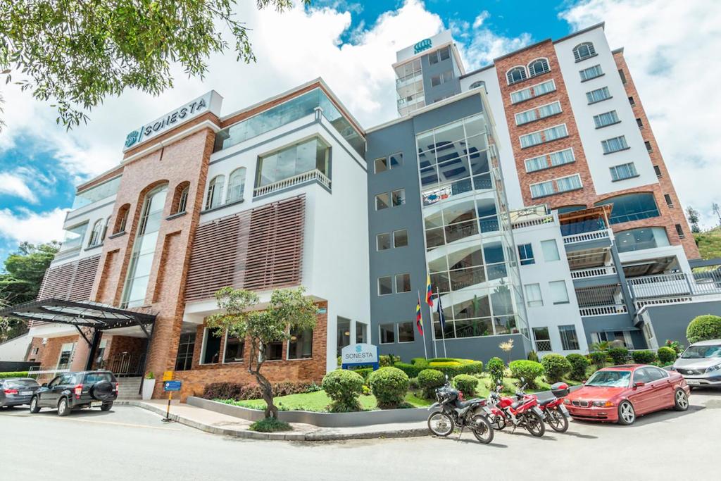 Un grupo de motocicletas estacionadas frente a un edificio. en Sonesta Hotel Loja, en Loja