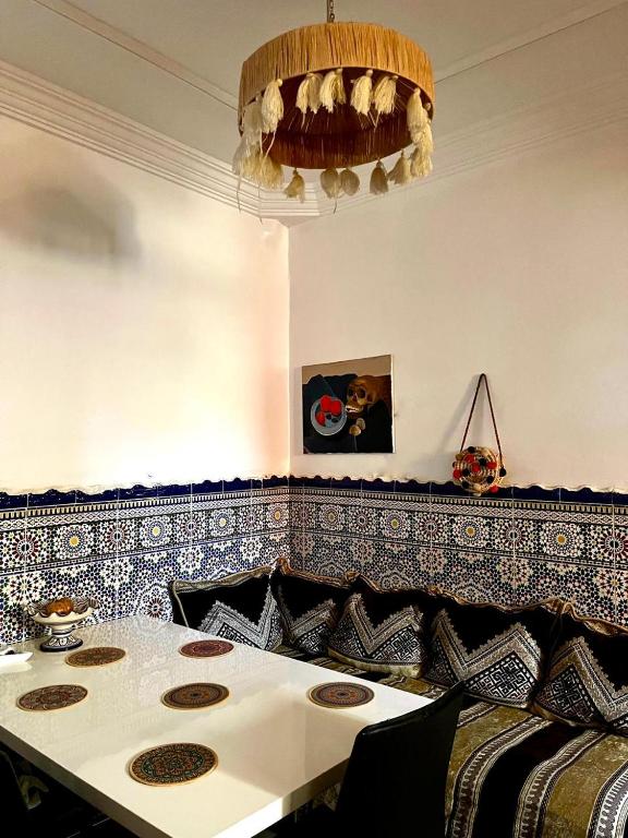 a dining room with a table and a chandelier at Dar Zina in Aourir