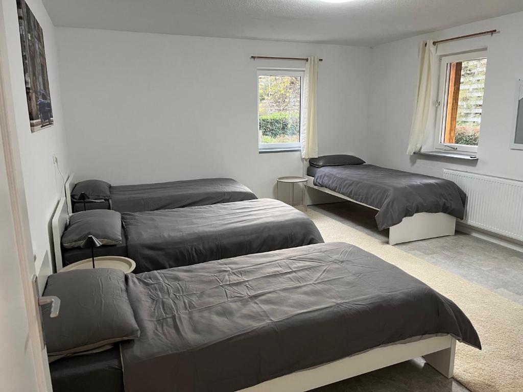 a room with three beds and two windows at Home15 Kassel in Kassel