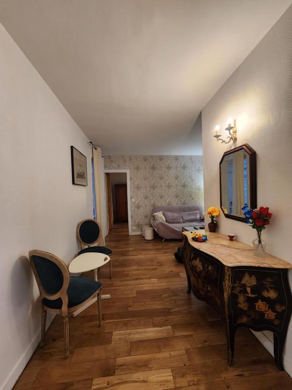 ein Wohnzimmer mit Tisch und Stühlen und einer Couch in der Unterkunft Évasion Parisienne exelmans et Tour Eiffel in Paris