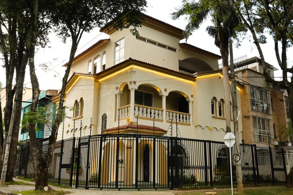 una grande casa bianca con una recinzione nera di Casa del Viento 102 a Cali