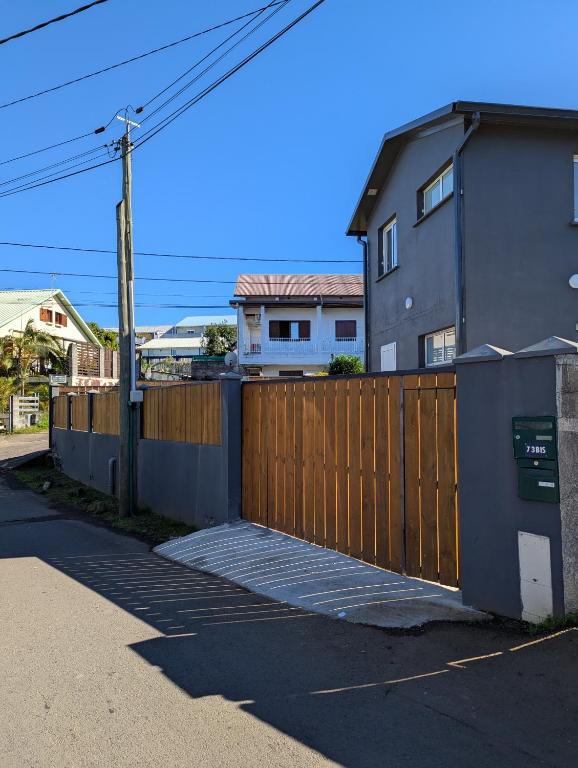 a wooden fence in front of a house at Le jamerosas in Le Tampon