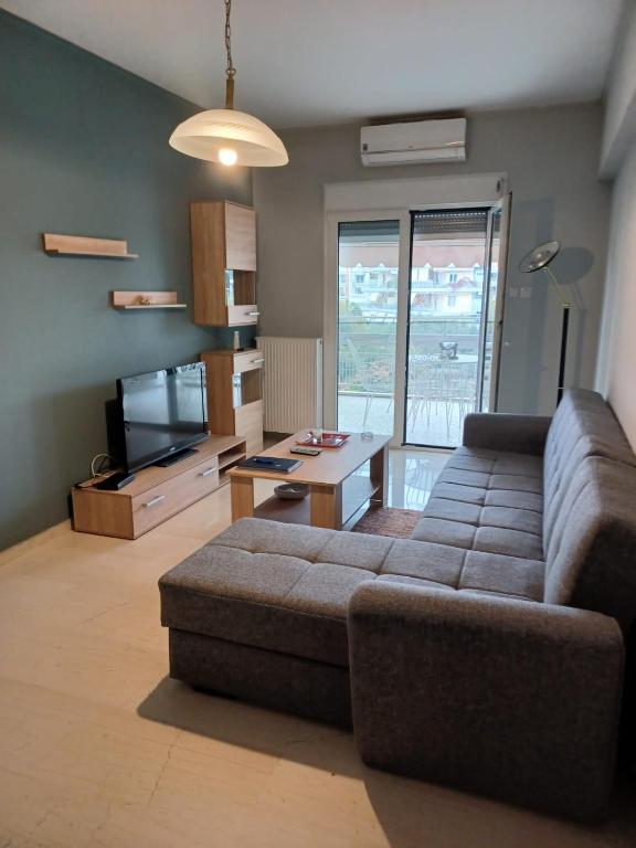 ein Wohnzimmer mit Sofa und Fernseher in der Unterkunft Sea and City Voula Suite by First Class Properties in Athen