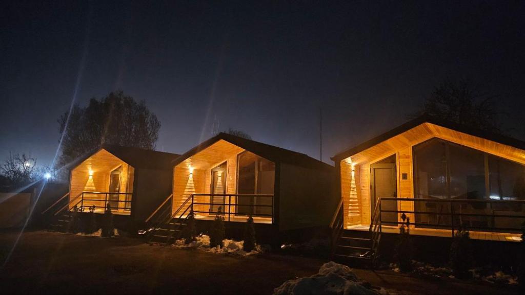 a couple of houses with lights on them at night at Aiwa Eco Hotel in Karakol