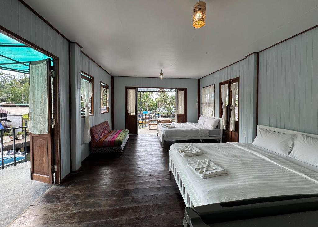 a bedroom with two beds and a balcony at คลองมาดโฮสเทลเกาะกูด Klongmad Hostel Kohkood 