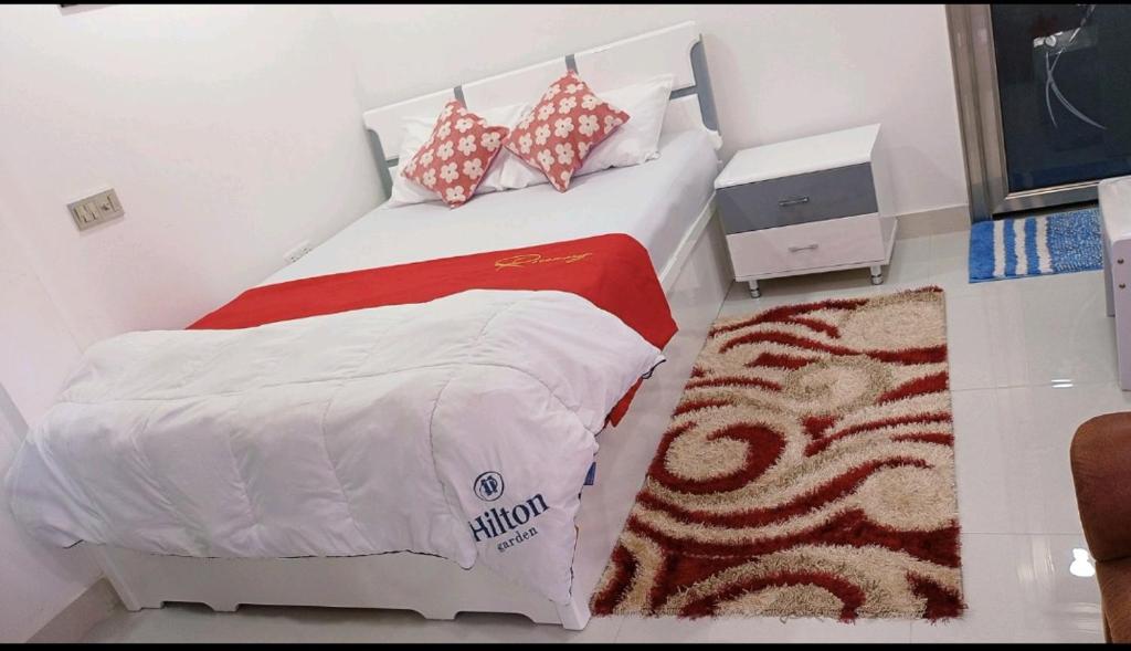 un dormitorio con una cama blanca con un edredón rojo y blanco en Save Sweet Home, 