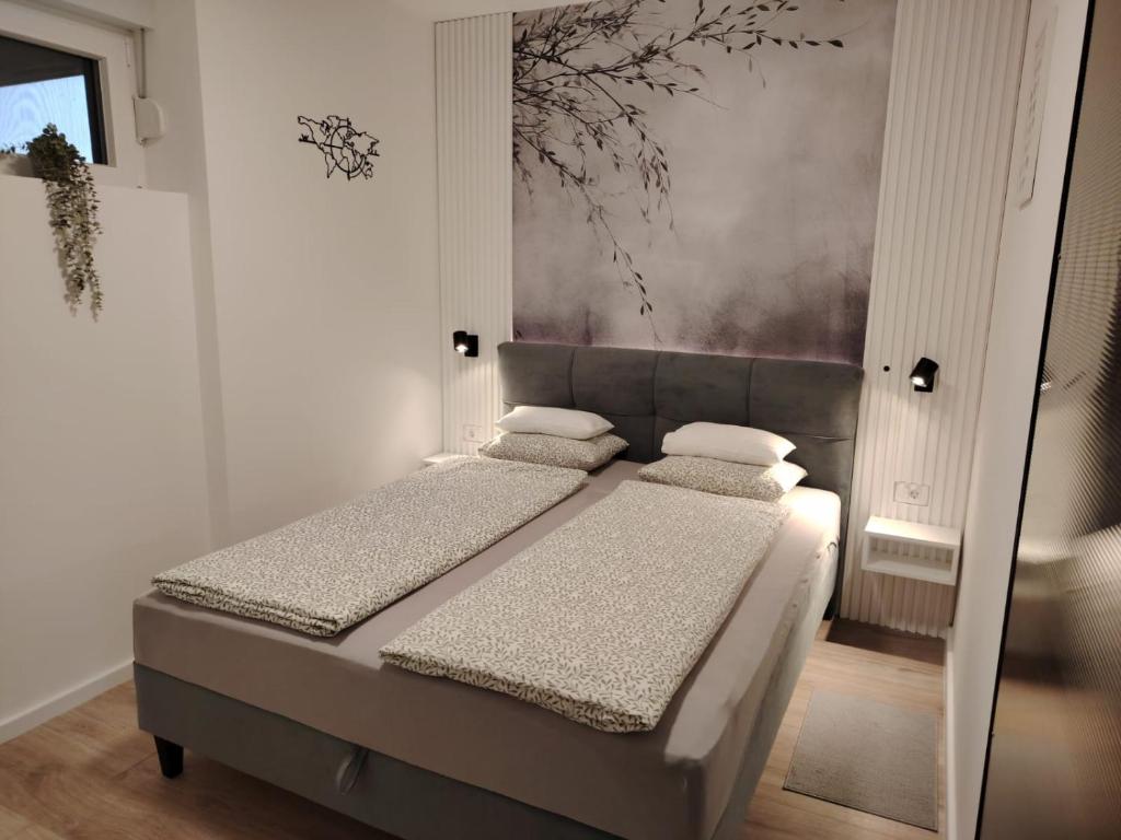 a bedroom with two beds and a painting on the wall at Apartman „Karolina” in Nova Gradiška