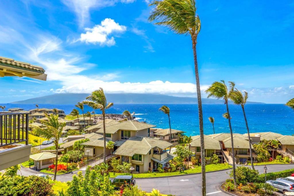 a view of a resort with palm trees and the ocean at Kapalua Bay Villas 2 Free Rental Cars KBM Resorts Premium Bay Villa 2 Units 3 Bedrooms ML-1604 in Honokahua