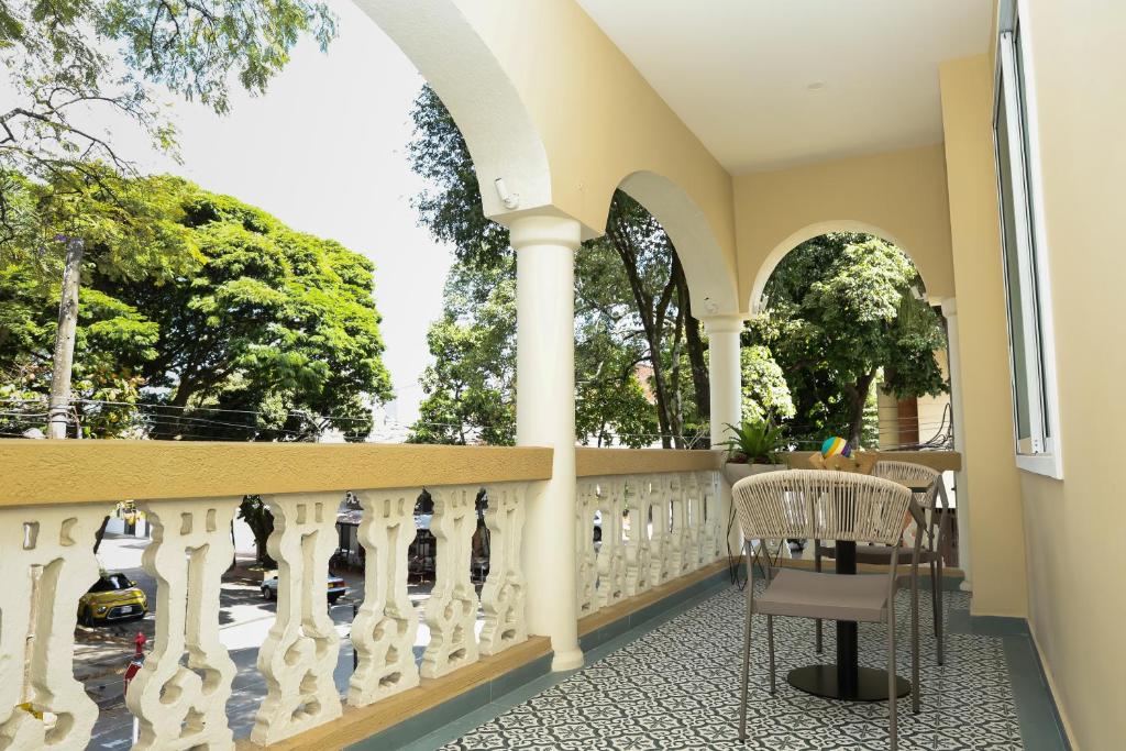 balcón con mesa, sillas y árboles en Casa del Viento 201, en Cali
