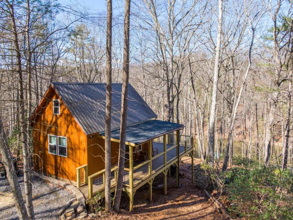 a cabin in the woods with a black roof at Retreat at Riverbend in West Jefferson