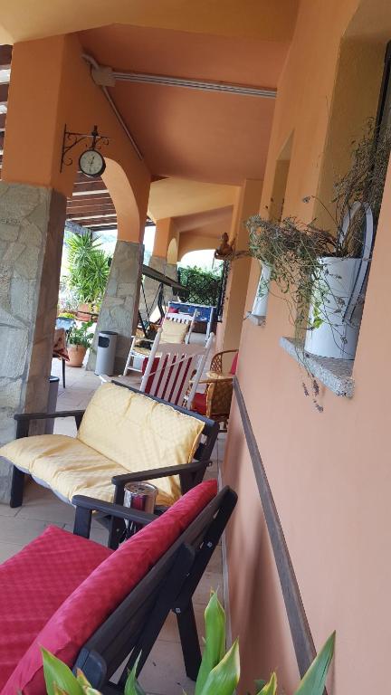 a balcony with a couch and chairs on a patio at Agriturismo Ticci in Seùlo