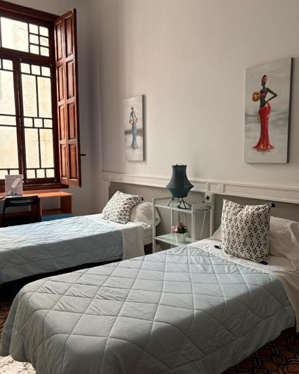 a bedroom with two beds and a window at The Cathedral Hostel in Murcia