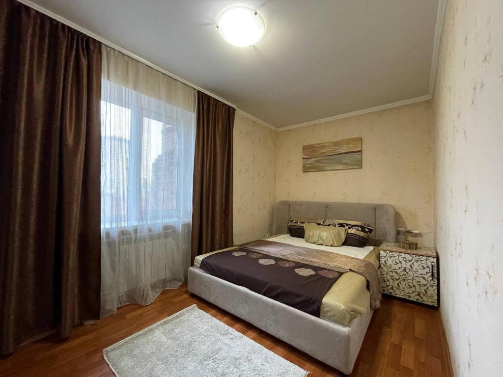 a bedroom with a bed and a large window at Воскресенская 1 Набережная 2 кв in Dnipro