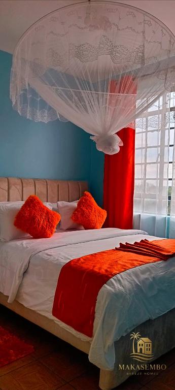 1 dormitorio con 1 cama con dosel rojo y blanco en Makasembo breeze homes, en Kisumu