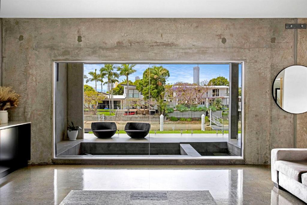 sala de estar con 2 sillas y ventana grande en Urban Hideaway Pet Friendly, en Gold Coast