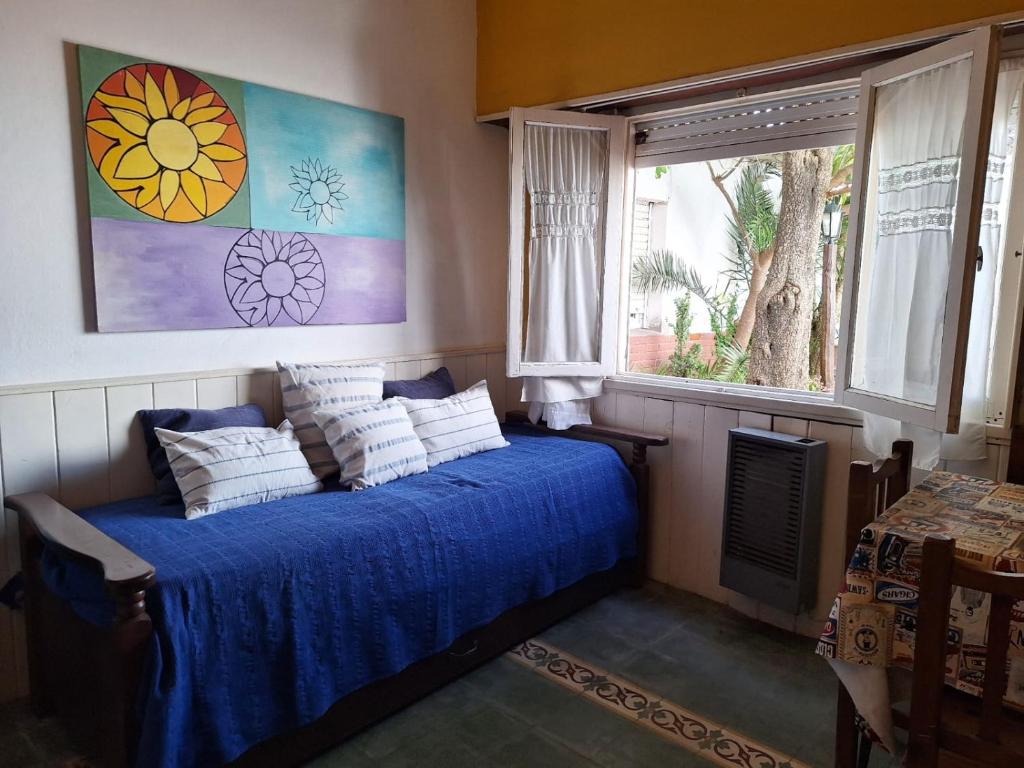 a bedroom with a blue bed with pillows and a window at La Vecindad del Sol Depto G in Miramar