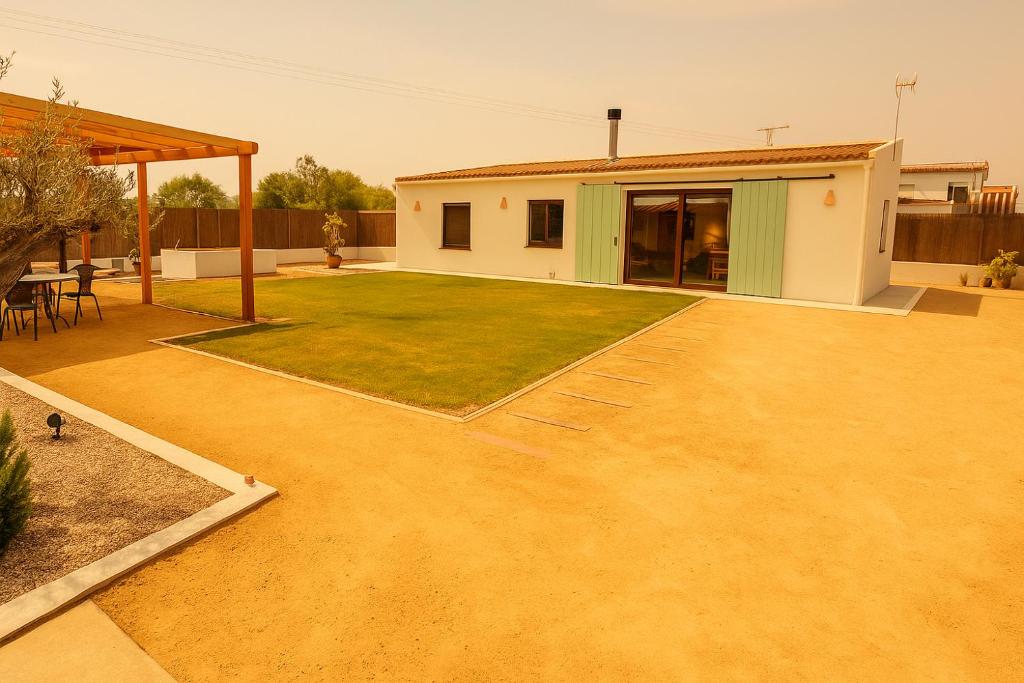 a backyard with a house and a lawn at Villa Salinas Beach Home Natural Park in La Manga del Mar Menor