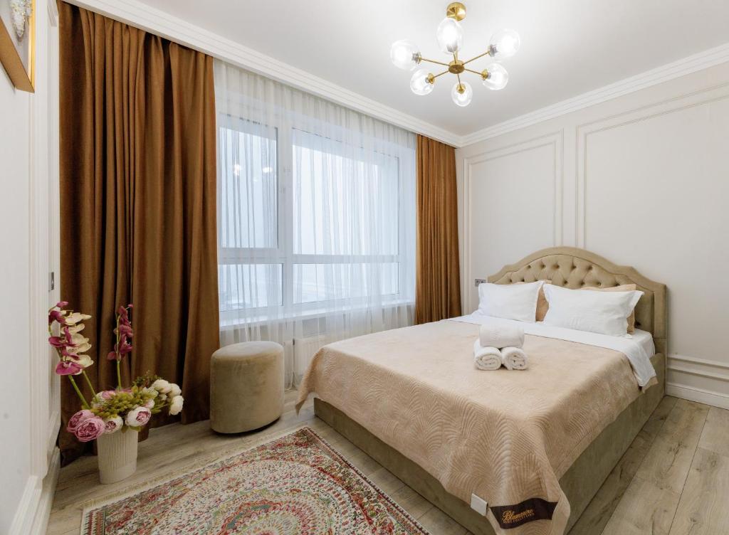 ein Schlafzimmer mit einem Bett mit zwei Handtüchern darauf in der Unterkunft Шикарные апартаменты возле Хан Шатыр in Astana