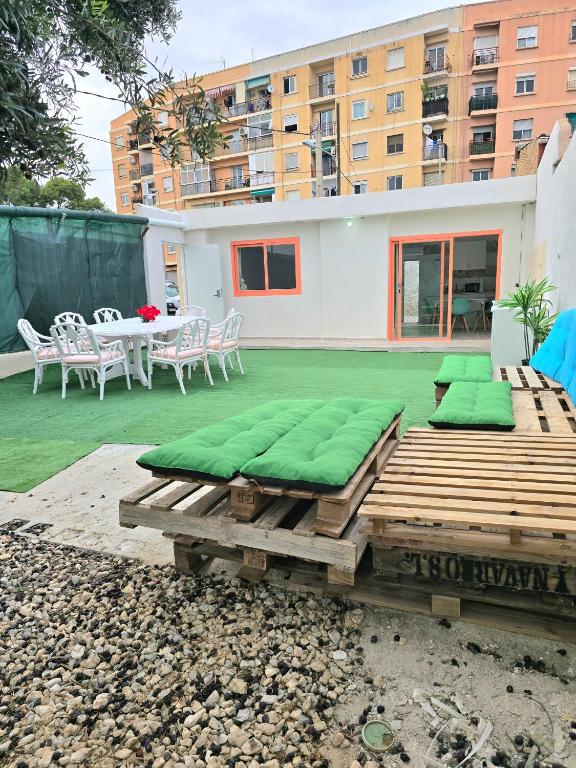 a patio with green cushions and a table and chairs at La Casita de Beni Valencia in Valencia