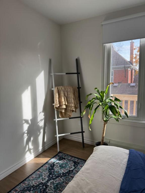 a bedroom with a bed and a plant next to a window at Affordable Elegance Modern 2BR Getaway in London