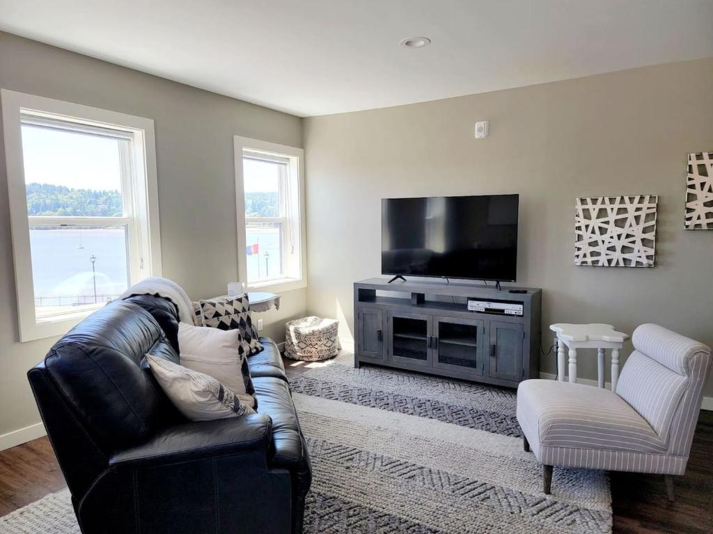 ein Wohnzimmer mit Sofa und Flachbildfernseher in der Unterkunft Liberty Bay Loft with Water views in Poulsbo