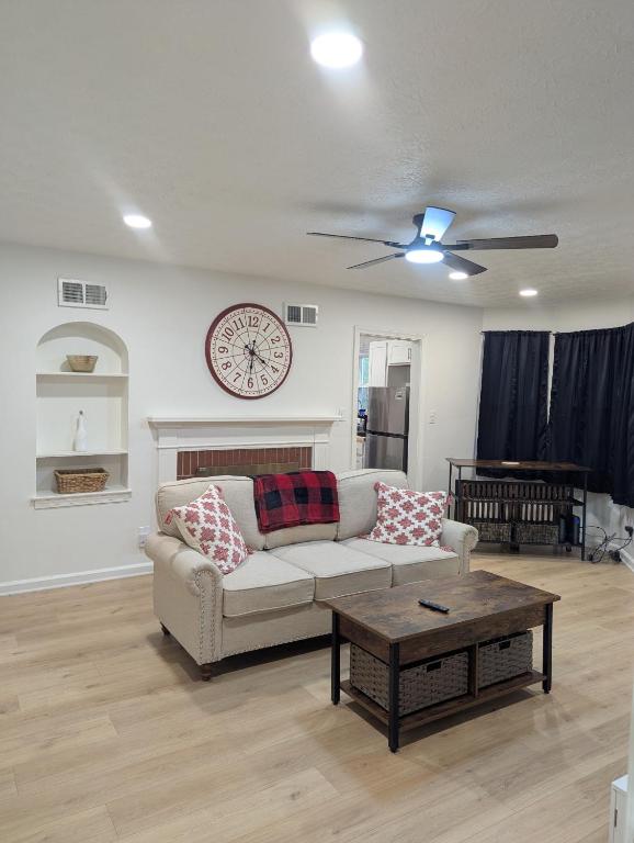 a living room with a couch and a clock on the wall at Oilgate at Parkgate in Akron