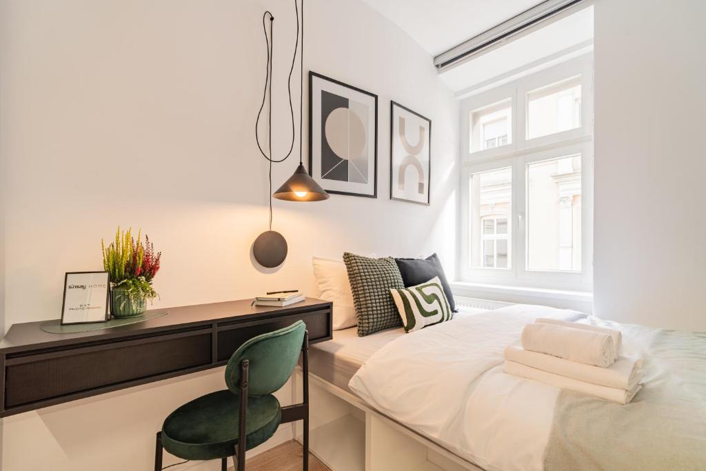 ein Schlafzimmer mit einem Bett, einem Schreibtisch und einem Stuhl in der Unterkunft Raciborska Old Town in Gliwice