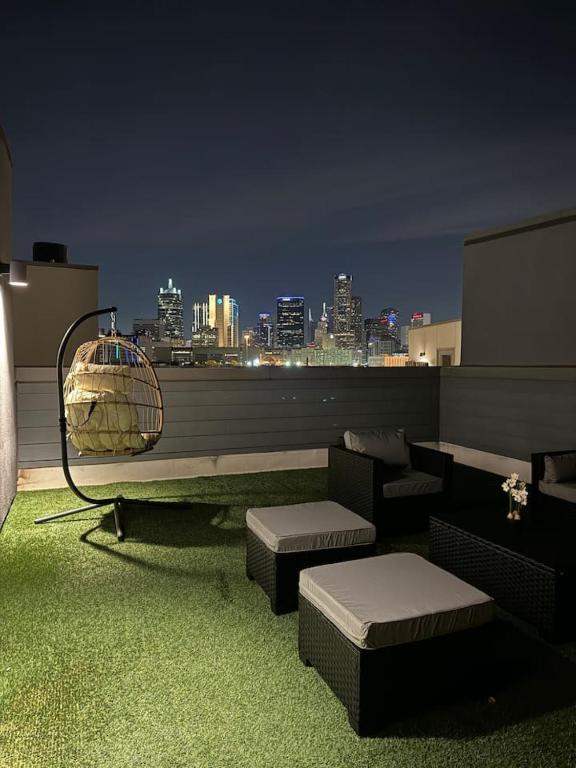 a rooftop patio with a view of a city at night at The Indigo 2BDTownhouse DownTown Walkable in Dallas