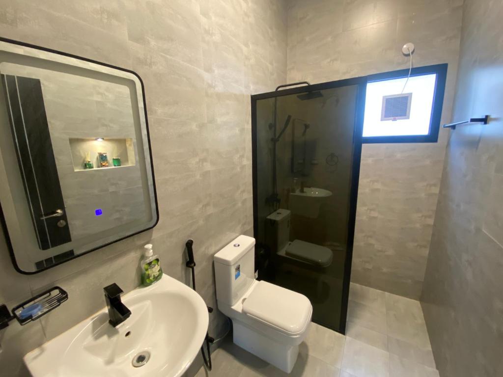 a bathroom with a toilet and a sink and a shower at لامور فيلا in Sohar