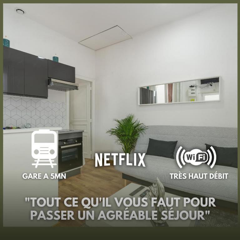 a living room with a couch and a kitchen at Le Petit Cosy de la Gare - Wifi in Drancy