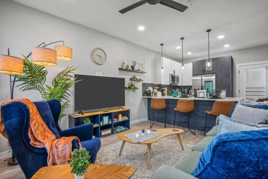 a living room with a blue couch and a tv at Elegant 2BD Townhome 7TH St Walkable in Fort Worth